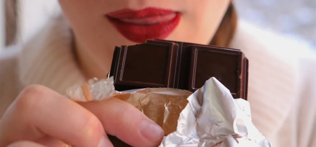femme avec un rouge à levre va manger du chocolat pour un moment de plaisir