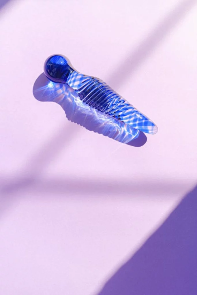 gode en verre sur un fond violet